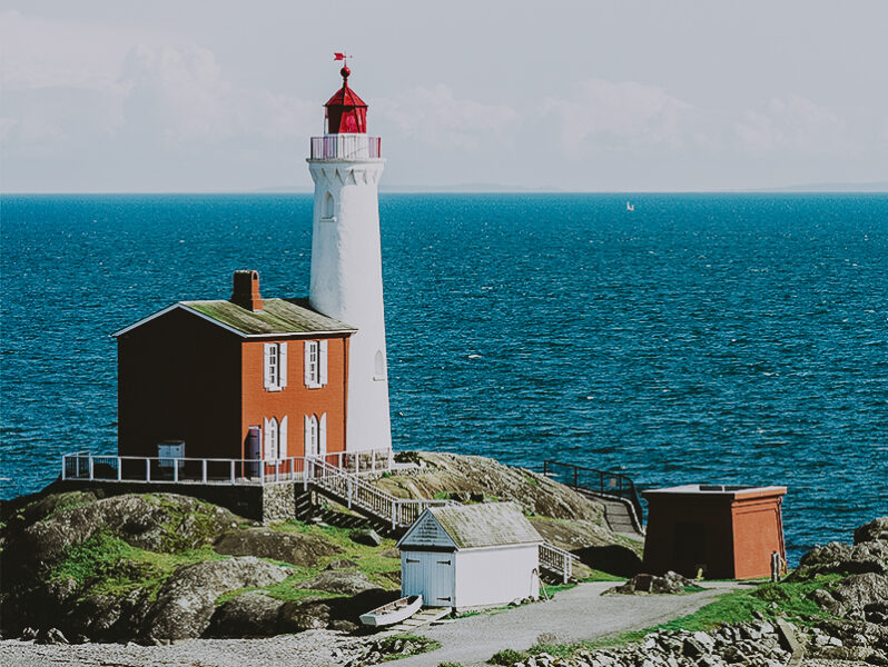 A red and white lighthouse near the ocean located at Fisgard Lighthouse