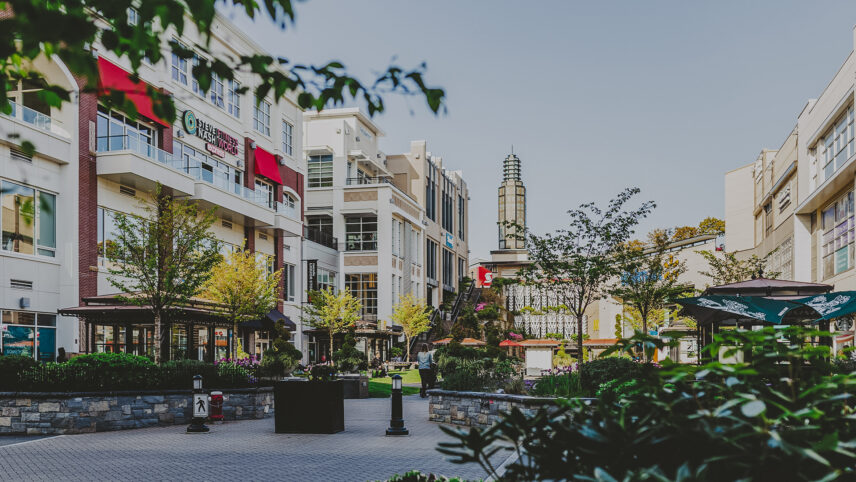 Saanich West neighborhood of Victoria, BC, showcasing a modern building with retail spaces, landscaped greenery, and a vibrant communal area