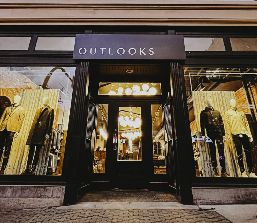 Exterior view of Outlooks storefront with mannequins in stylish clothing displays