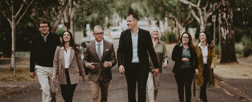 A professional group photo of the Clover Residential real estate team walking outdoors, showcasing collaboration and expertise in Victoria, BC