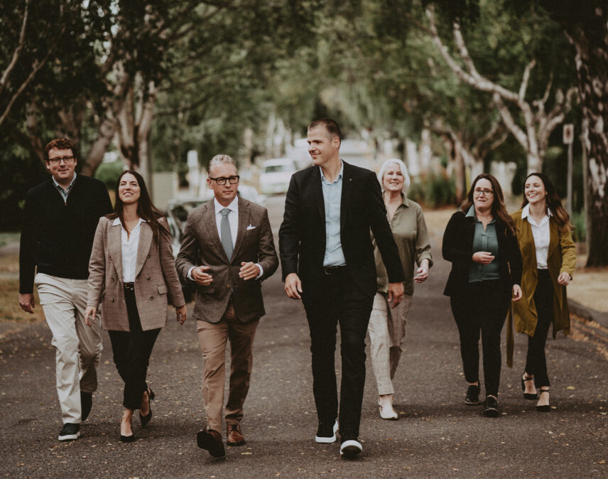 A candid team photo of David Logan, Ole Schmidt, and the dedicated Clover Residential team walking outdoors, showcasing collaboration and commitment to real estate excellence in Victoria, BC