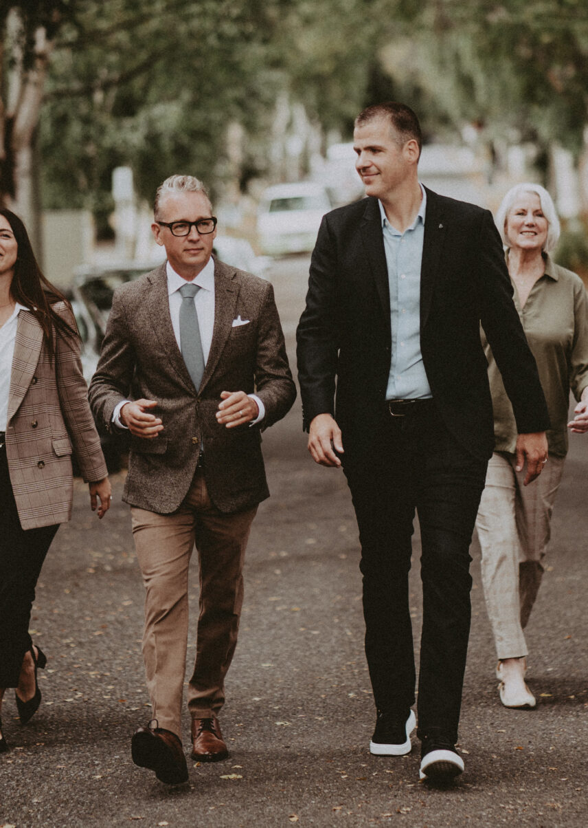 Ole Schmidt, David Logan, and Cindy Hayworth walking on a tree-lined residential street in Victoria, BC
