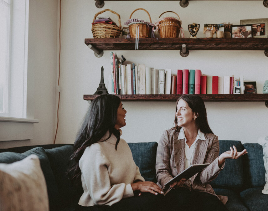 Real estate agent sharing insights with a client in a beautifully styled living space, representing Folio Group at Clover Residential in Victoria, BC