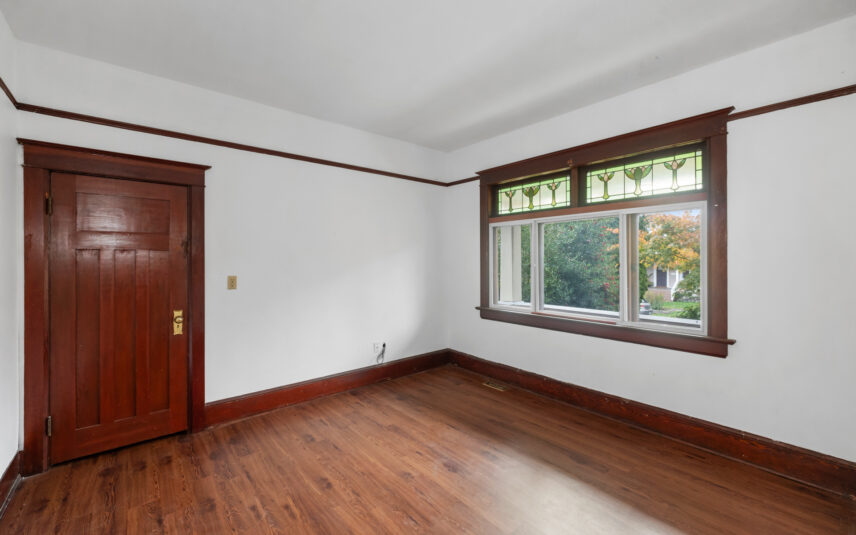 Spacious bedroom at 624 Cornwall Street Victoria BC listed by Folio Group at Clover Residential featuring stained glass details large windows and wood trim in the Fairfield neighborhood