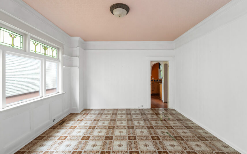 Spacious room at 624 Cornwall Street Victoria BC listed by Folio Group at Clover Residential featuring patterned tile flooring stained glass windows and access to the kitchen in the Fairfield neighborhood