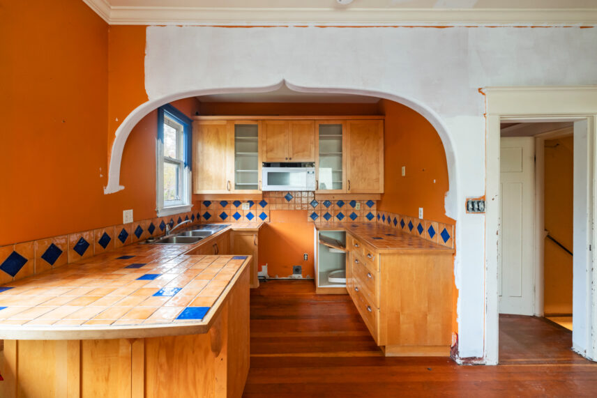 Colorful kitchen at 624 Cornwall Street Victoria BC listed by Folio Group at Clover Residential featuring tiled countertops with blue accents wooden cabinetry and an arched doorway in the Fairfield neighborhood