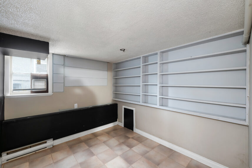 Lower-level room at 624 Cornwall Street Victoria BC listed by Folio Group at Clover Residential featuring built-in shelving tiled flooring and a window for natural light in the Fairfield neighborhood