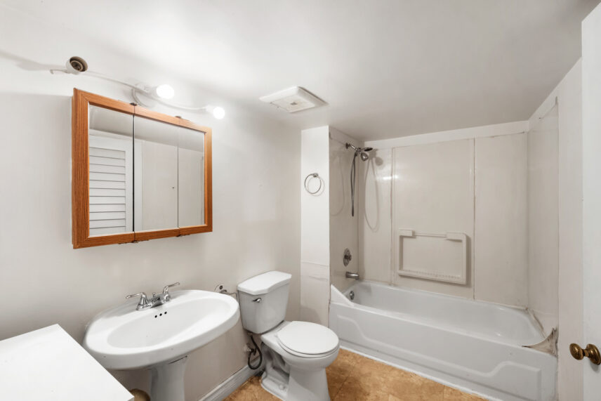 Lower-level bathroom at 624 Cornwall Street Victoria BC listed by Folio Group at Clover Residential featuring a bathtub shower combination pedestal sink and bright lighting in the Fairfield neighborhood