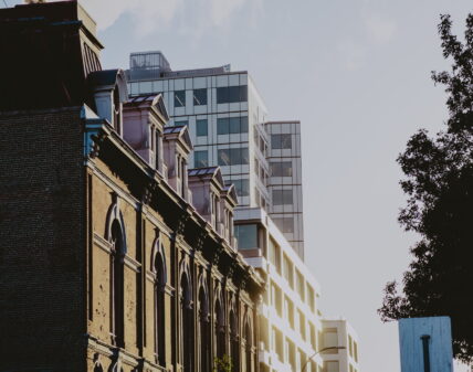 Historic brick building juxtaposed with modern high-rise architecture in downtown Victoria, BC