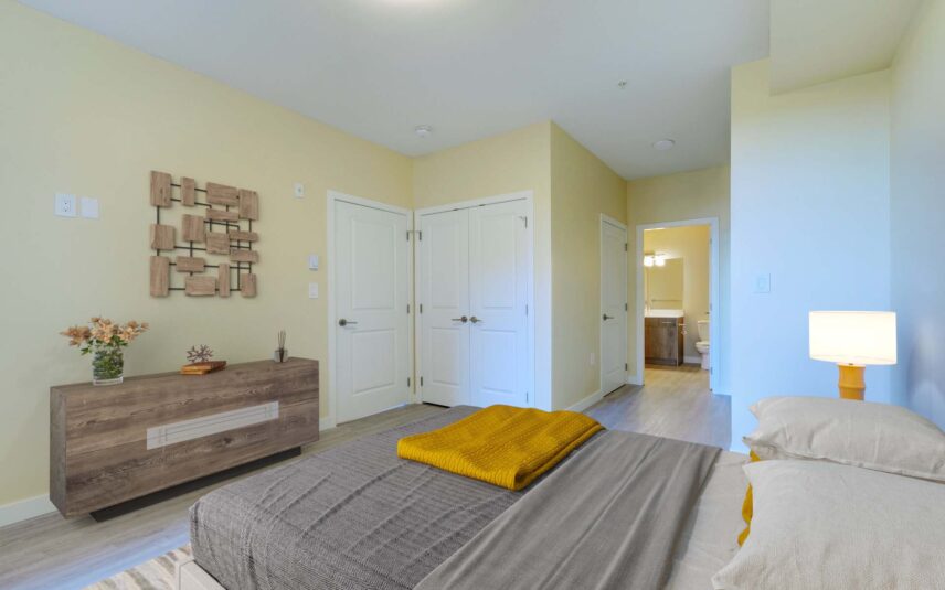 Bright bedroom with dual closets and en-suite bathroom access at 101 Presley Place, Unit 110, listed by Folio Group at Clover Residential in Victoria, BC