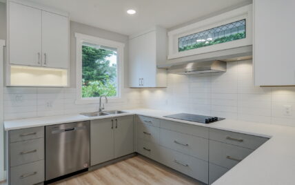 Modern kitchen with sleek cabinetry, stainless steel appliances, quartz countertops, and a window offering natural light at 337 Robertson Street, managed by Clover Residential in Victoria, BC