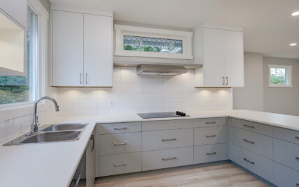 Bright and modern kitchen featuring custom cabinetry, quartz countertops, a double sink, and a built-in cooktop at 337 Robertson Street, managed by Clover Residential in Victoria, BC