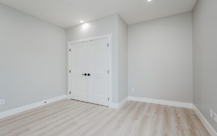 Bedroom featuring double closet doors, light wood laminate flooring, and recessed lighting at 337 Robertson Street, managed by Clover Residential in Victoria, BC