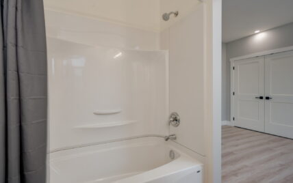 Bathroom featuring a full-size bathtub and shower combination with modern fixtures and adjacent bedroom access at 337 Robertson Street, managed by Clover Residential in Victoria, BC