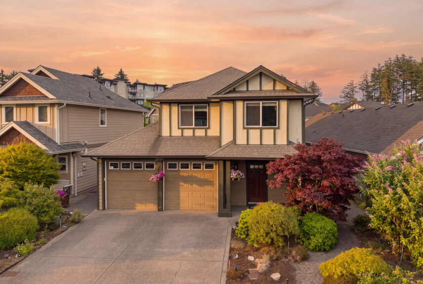 Double garage detached home at sunset in Westhills Langford BC with mature landscaping and Japanese maple