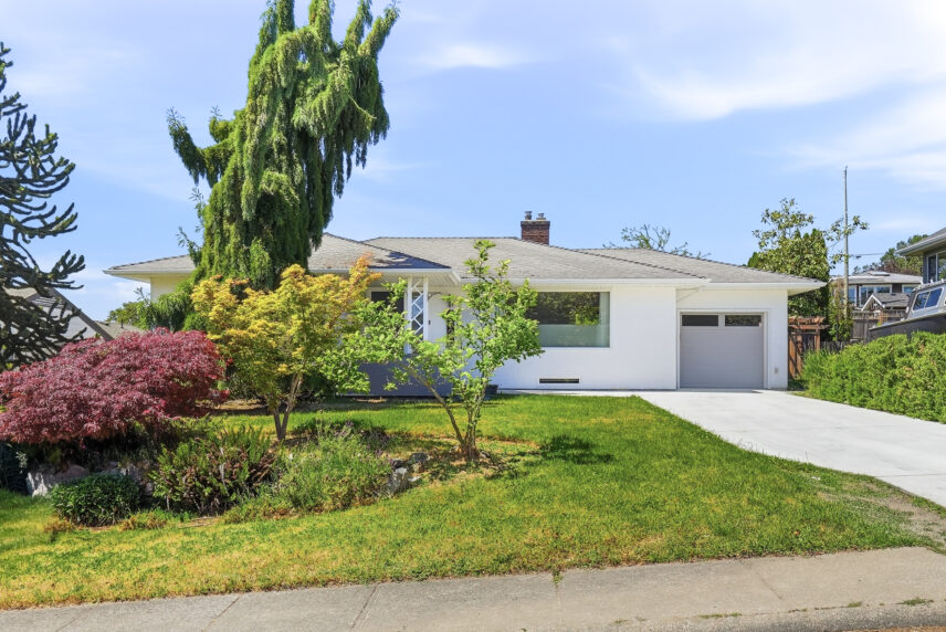 White rancher home at 3026 Larkdowne Road with attached garage and landscaped front yard in Victoria, BC