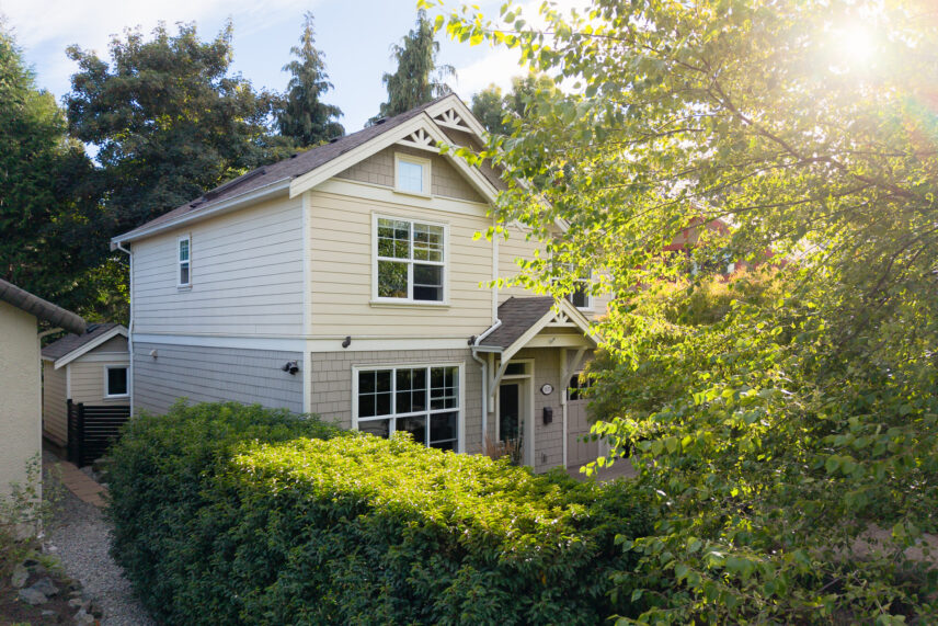 Custom-built 2015 home exterior at 1115 Faithful St in Fairfield, Victoria BC, surrounded by mature trees and greenery