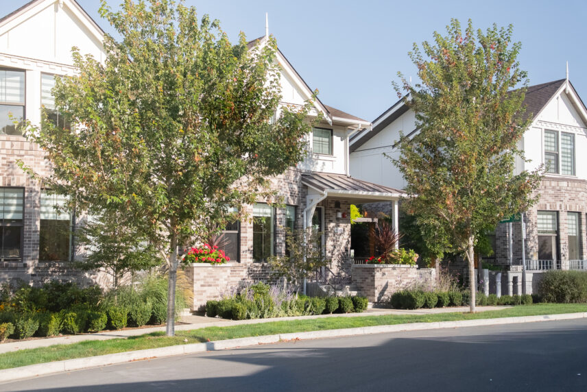 rick exterior of an executive end-unit townhome at 1048 Pentrelew Place in Rockland, Victoria BC, with mature landscaping and tree-lined street